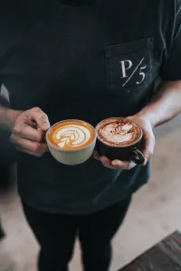 Man holding a Mocha in one hand and Latte in the other