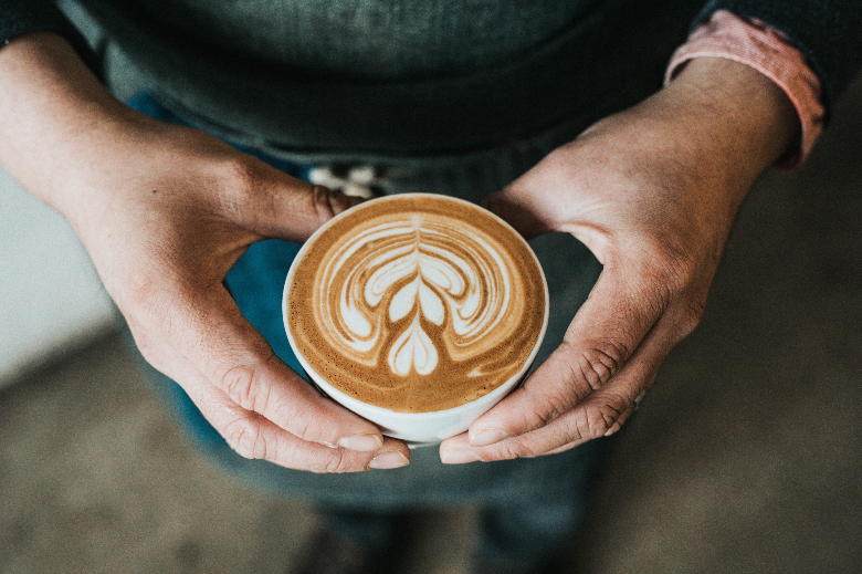 man holding coffee with rosetta on top